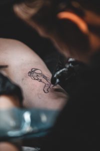 Tatuatorka wykonująca pierwsze linie, po których klientka dowie się, czy tatuaż boli, czy nie.