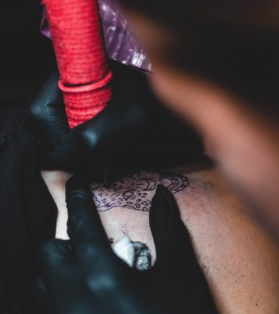 Tatuatora wykonuje dziarę i instruuje klientkę jak dbać o tatuaż
